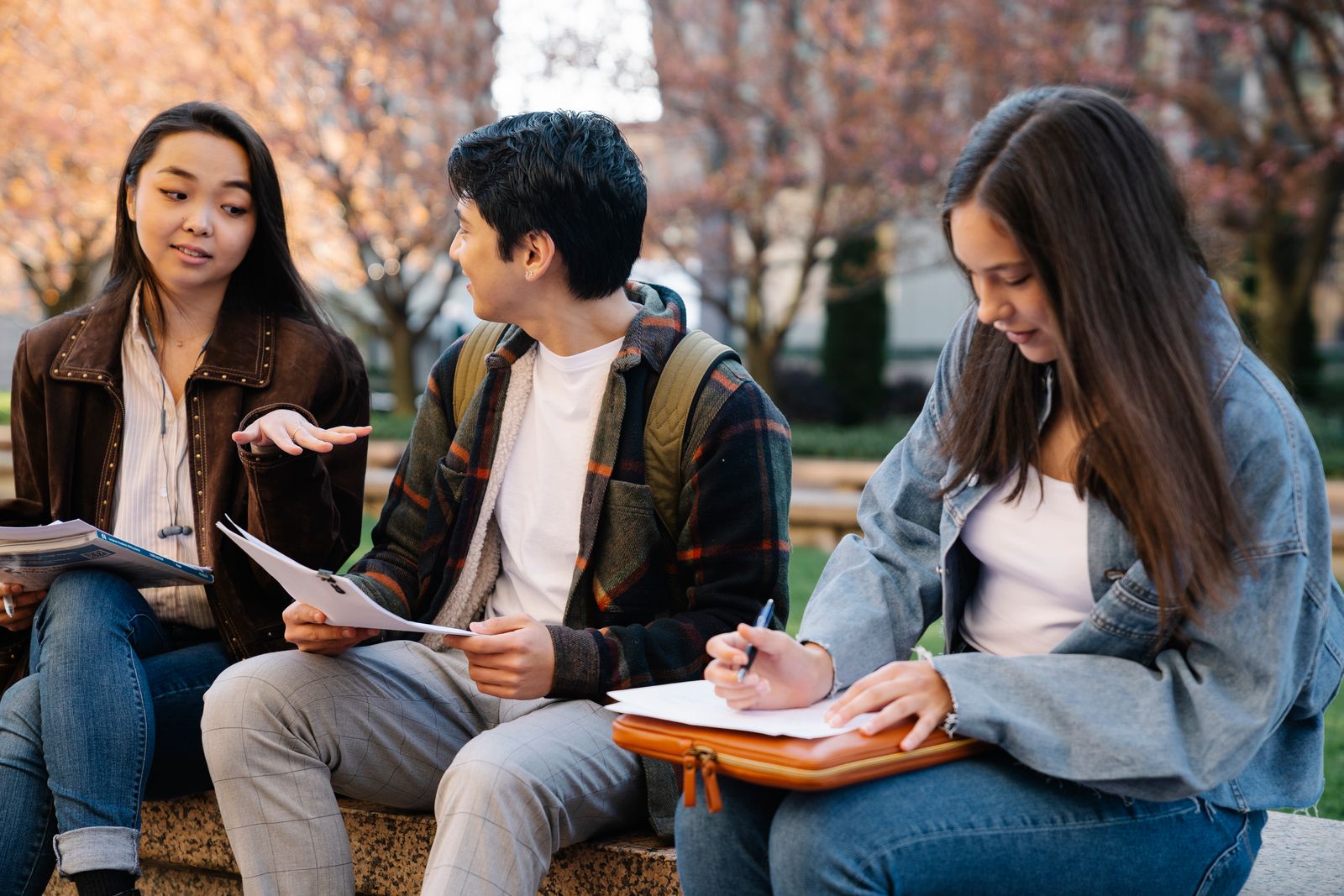 Three undergraduates comparing course catalogs while deciding between a social work and a psychology major